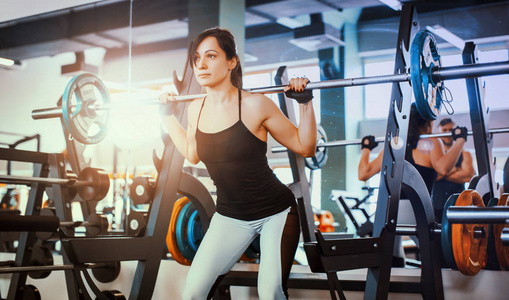 美丽的健身妇女举杠铃.运动型女子举重.照片