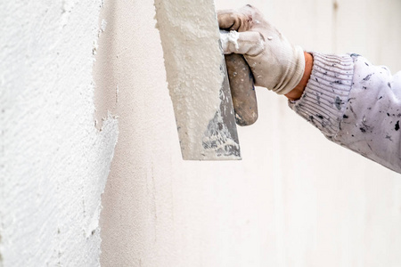 施工人员用水泥抹平混凝土墙面照片