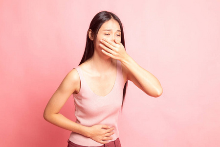 年轻的亚洲女人胃痛得快要呕吐了.照片