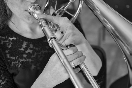 一个女孩手上弹奏着黑白长号的形象照片