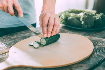 男人切黄瓜做健康可口的沙拉图片