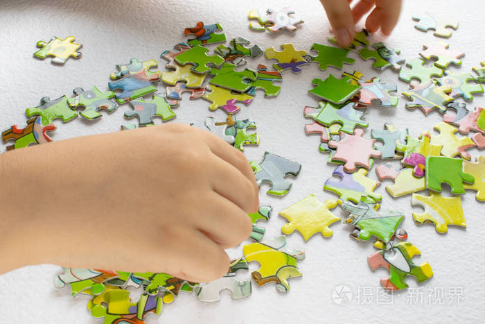 孩子玩拼图游戏孩子的手用彩色玩具拼图