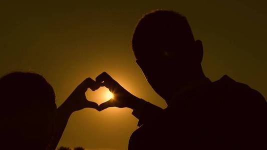 太阳在手.一对恩爱夫妻的团队合作.相爱的情侣用手表示心意.