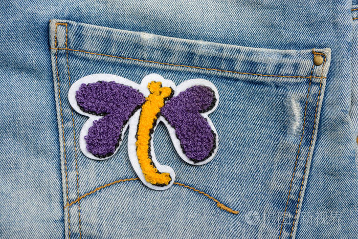 牛仔裤上的蝴蝶布补丁