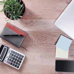 计算器,智能手机和商务配件放在木桌上照片