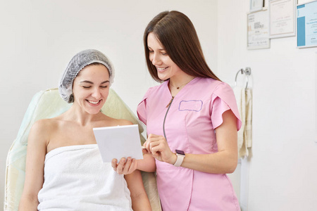 护肤过程美容医生的画像讲述了年轻漂亮的美容院的年轻女子在面部注射