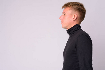 穿高领毛衣的金发男青年侧影照片