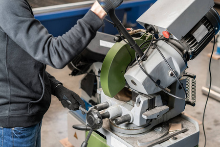 一名工业工程师,用锋利的圆锯片复合斜切锯切割金属和钢照片