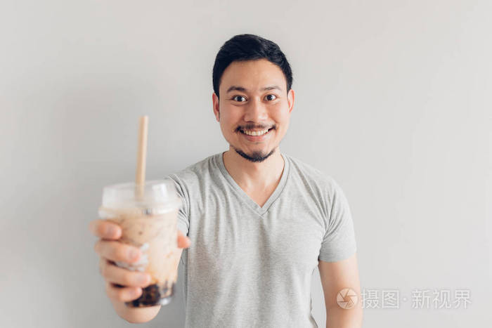快乐的男人在喝泡泡奶茶或珍珠奶茶亚洲和台湾流行的奶茶