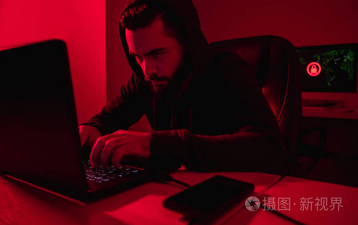 黑客在暗室里用笔记本电脑