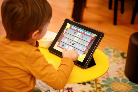 儿童玩游戏孩子在家里在床上用平板电脑.