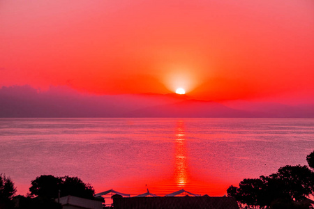 日落时穿着一件发光头发的迷人女孩的肖像在水面上发光的天堂日落.