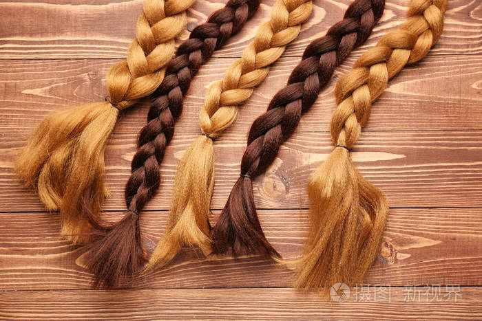 木质背景上的编织线。毛发捐献的概念