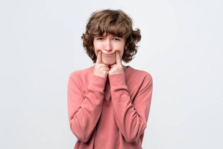 嘴角女人用手指张开嘴角假装微笑照片