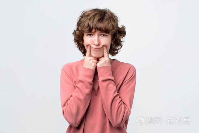 女人用手指张开嘴角假装微笑