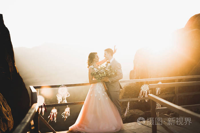 美丽的新婚夫妇在山边亲吻拥抱景色完美