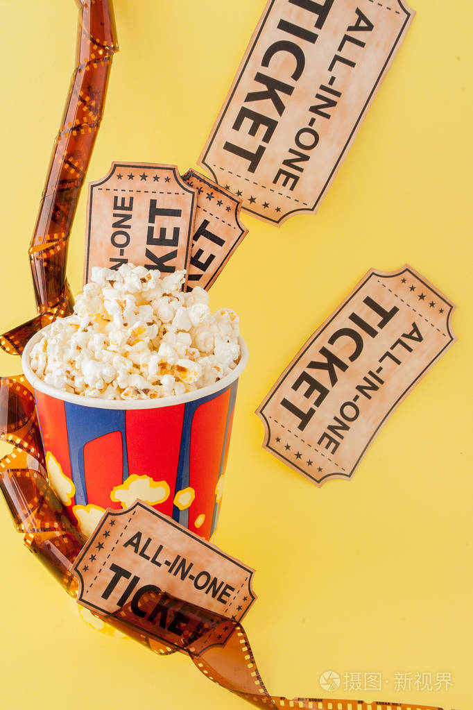 蓝色背景的电影票电影带和爆米花复制文本空间