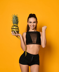 带卷尺和菠萝的运动型女性腰部图片