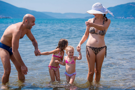 快乐的一家人在海滩上互相泼水图片