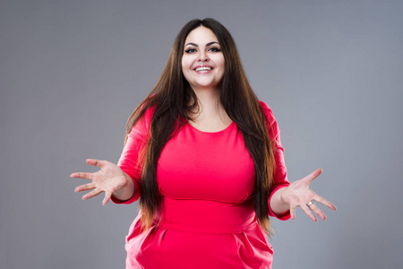 快乐的黑发大码模特,灰色背景的长发胖女人,身材积极照片