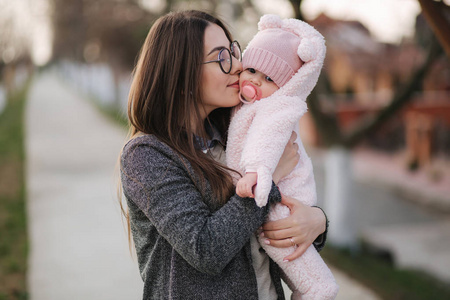 年轻的母亲带着她的小宝宝.妈妈用手抱着孩子.幸福的家庭照片