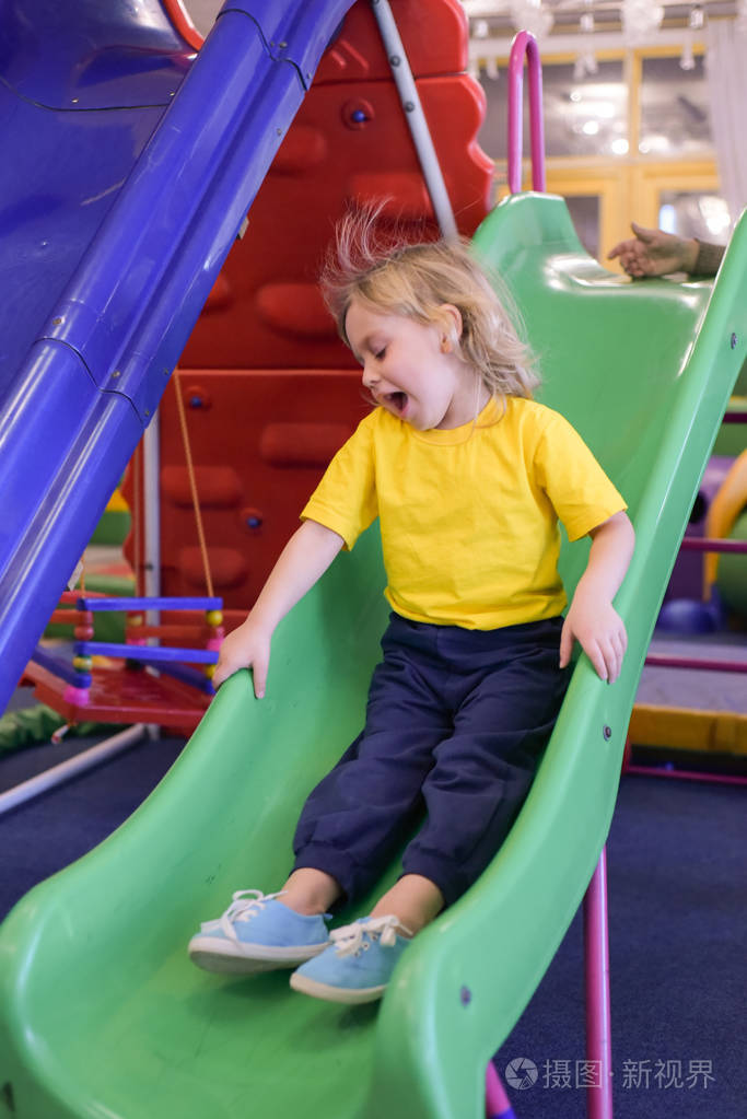 一个穿着黄色t恤的金发男孩的画像.孩子微笑着在儿童游戏室玩耍.jpg