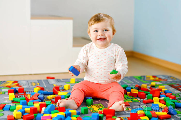 可爱的小女孩在玩益智玩具。快乐健康的孩子在家里用五颜六色的木块在家里玩耍。宝宝学习颜色和形状