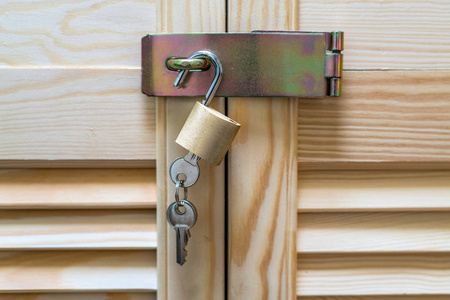 衣柜钥匙带钥匙的金属锁挂在现代木制橱柜上,带有古典乡村风格的条带.