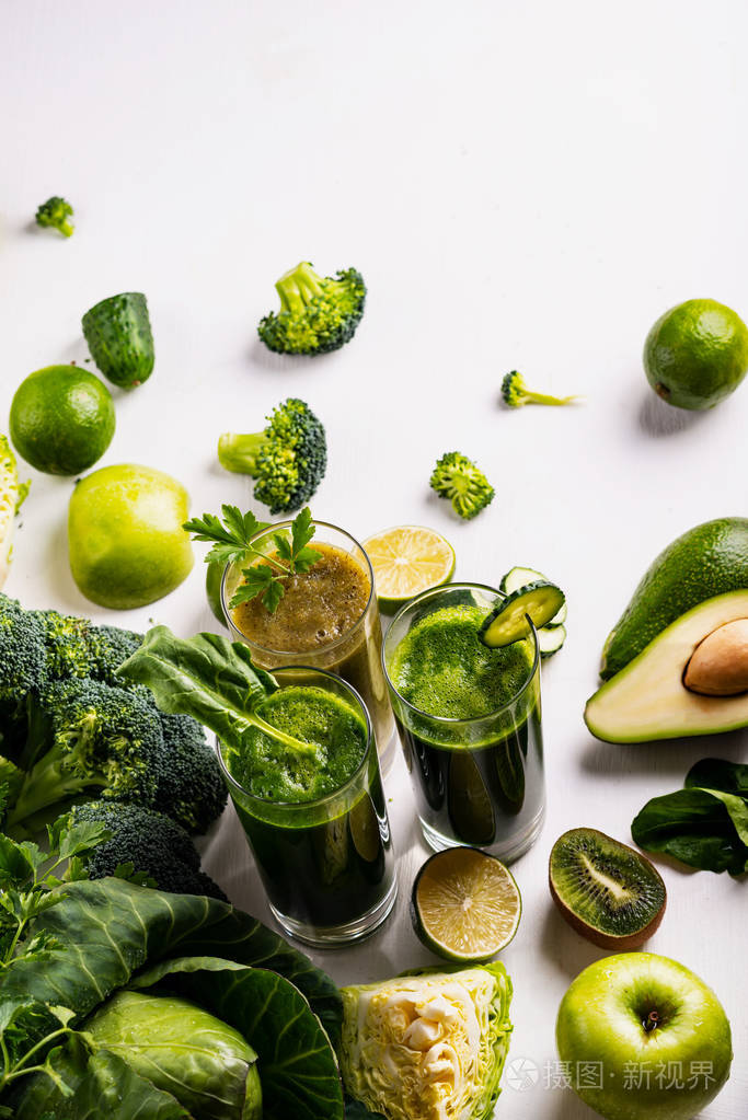 白色木质背景上有不同的健康纯素菠菜猕猴桃和黄瓜饮料生饮料和食物