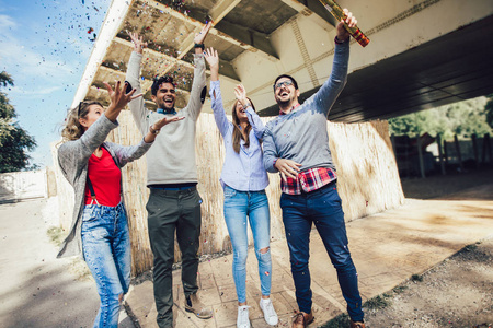 group of friends enjoying party and throwing confetti. 照片