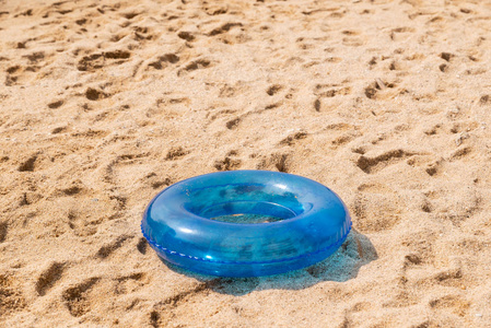 沙滩上的蓝色充气游泳圈照片