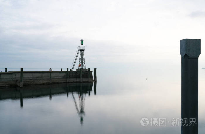 信号灯和港湾墙在平静的湖水下