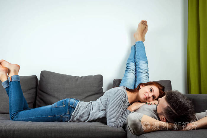 一对恩爱夫妻躺在家里的床上一个懒散的家庭在周末休息家庭关系爱情