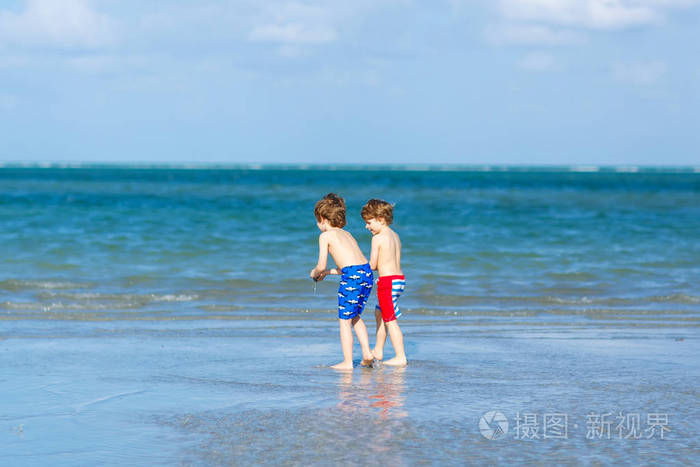 兄弟姐妹,兄弟姐妹,一对双胞胎在背景上看着手掌.家庭远洋度假.