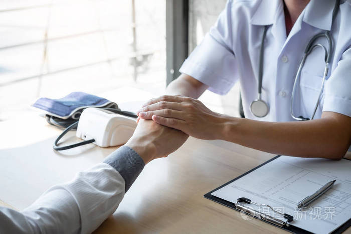 医生牵着病人的手鼓励谈笑风生