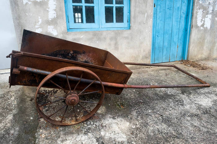 房子附近有两个轮子的旧农用车