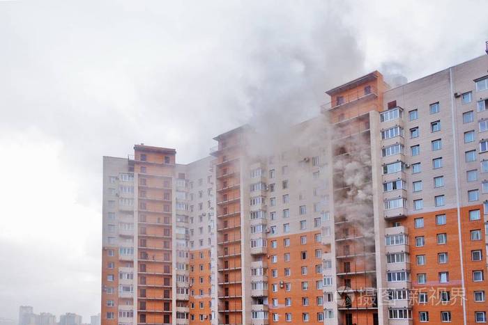 一所大公寓的火灾.几层楼着火,烟从窗户冒出来.办公楼着火冒烟.