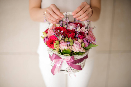 一个女孩拿着一个漂亮的粉红色和红色的花篮照片