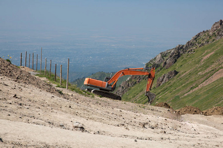 挖掘机在山顶挖了一个洞,可以俯瞰城市.摄于哈萨克斯坦照片