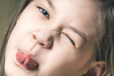 可爱漂亮的露舌头的女孩照片