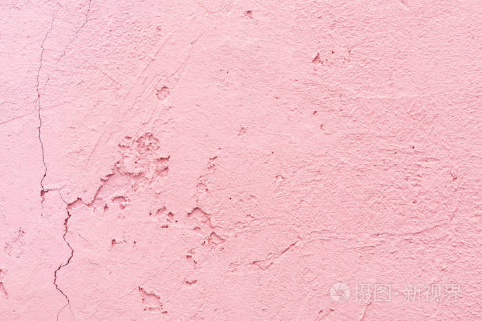 粉红色灰泥墙的破裂纹理特写抽象背景