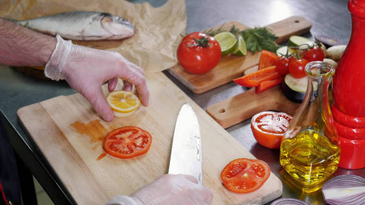 厨房里切西红柿和柠檬的厨师图片