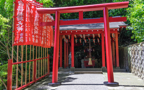 大田县一个传统的红色托里和日本吉冈美谷神道神社的细节视图,由旗帜