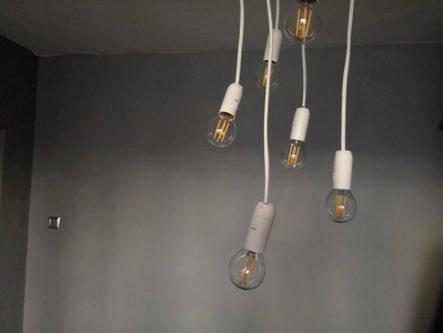 从天花板上挂在电线上的灯泡照片