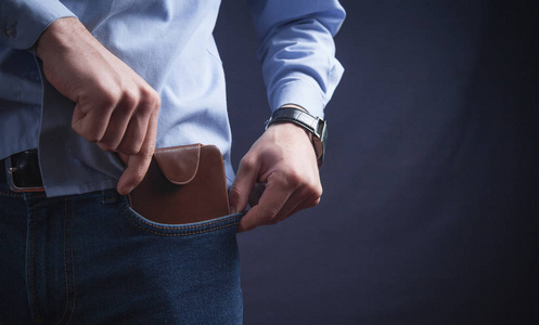 商人正在从口袋里掏出钱包.照片