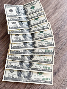 在古老的木质背景上用小钱包擦亮兹罗提木质桌子背景上的粉红色钱包