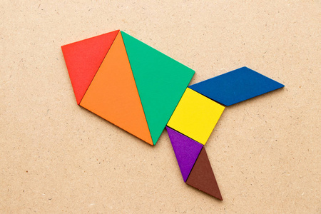 木质背景上火箭或导弹形状的七巧板(新体验概念,启动项目)照片