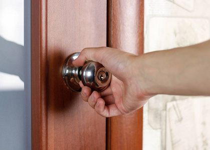 手通过把手打开门.闭合照片