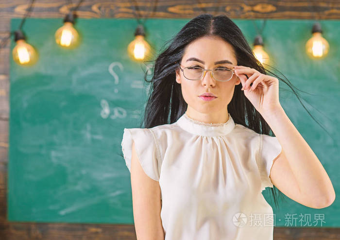 教室里站着一位留着长发穿着白衬衫的妇女女严老师面无表情地站在黑板