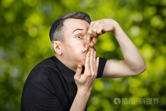 一个头发灰白感觉恶心的年轻人的画像他捂住嘴和鼻子以防臭气熏天绿色